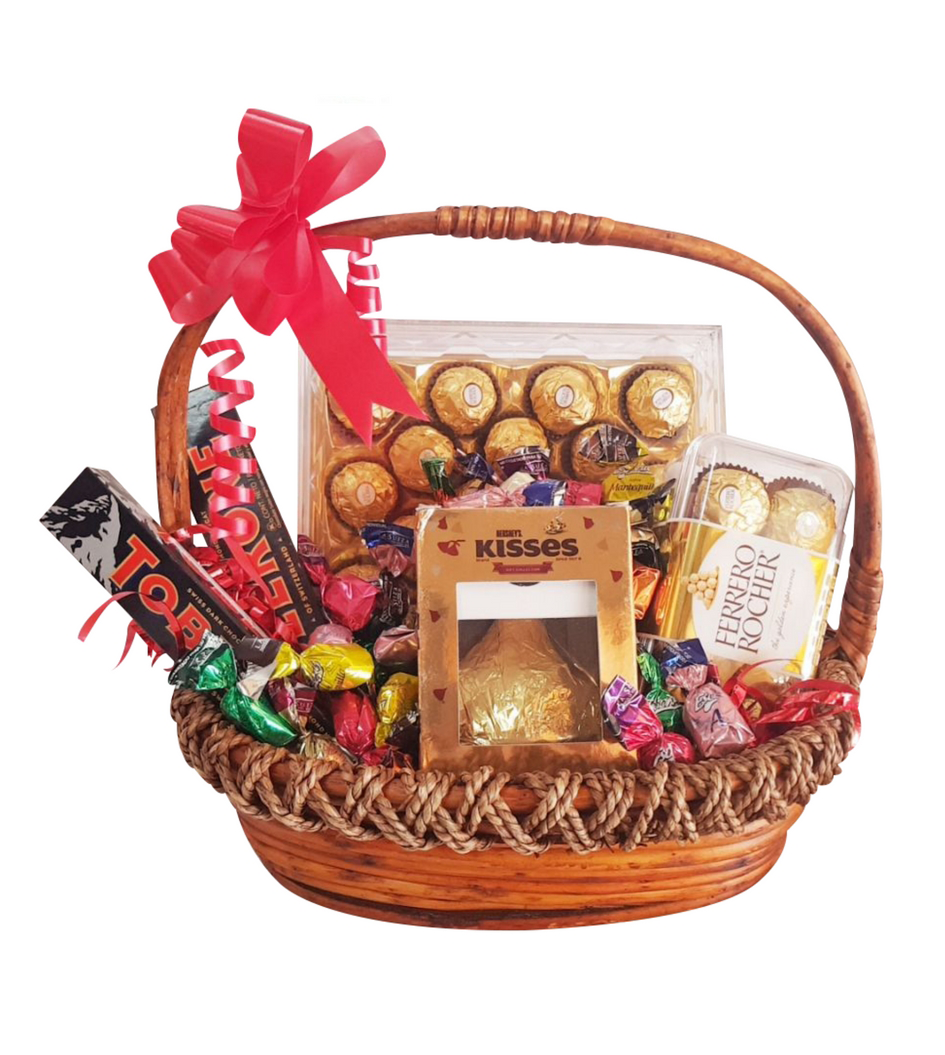 Canasta compuesta de una caja de chocolates finos Ferrero Rocher de 24 piezas y una de 16 piezas, 2 barras de chocolate Toblerone de origen suizo, una caja de chocolate kisses y dulces de sabores.