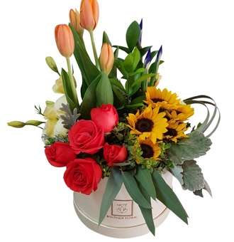 Elegante caja de flores, tulipanes, rosas girasoles en perfectos tonos naranjas
