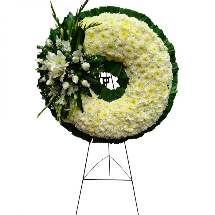 Fina corona compuesta por crisantemos, rosas y flores de casa blanca